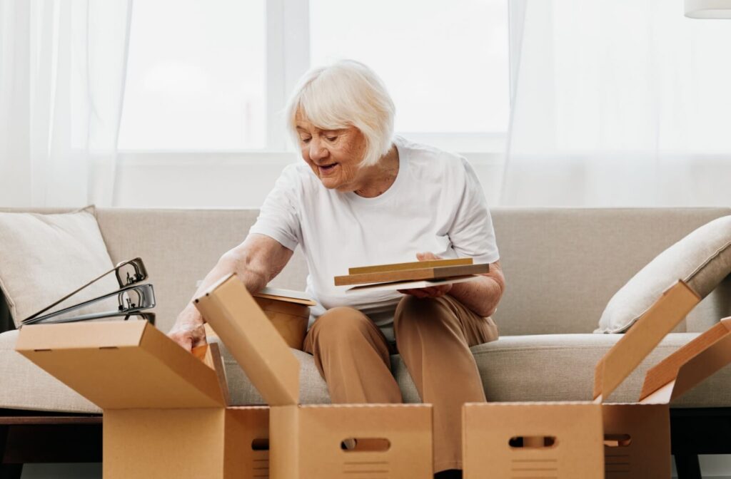 Senior going through items, and placing them in moving boxes.