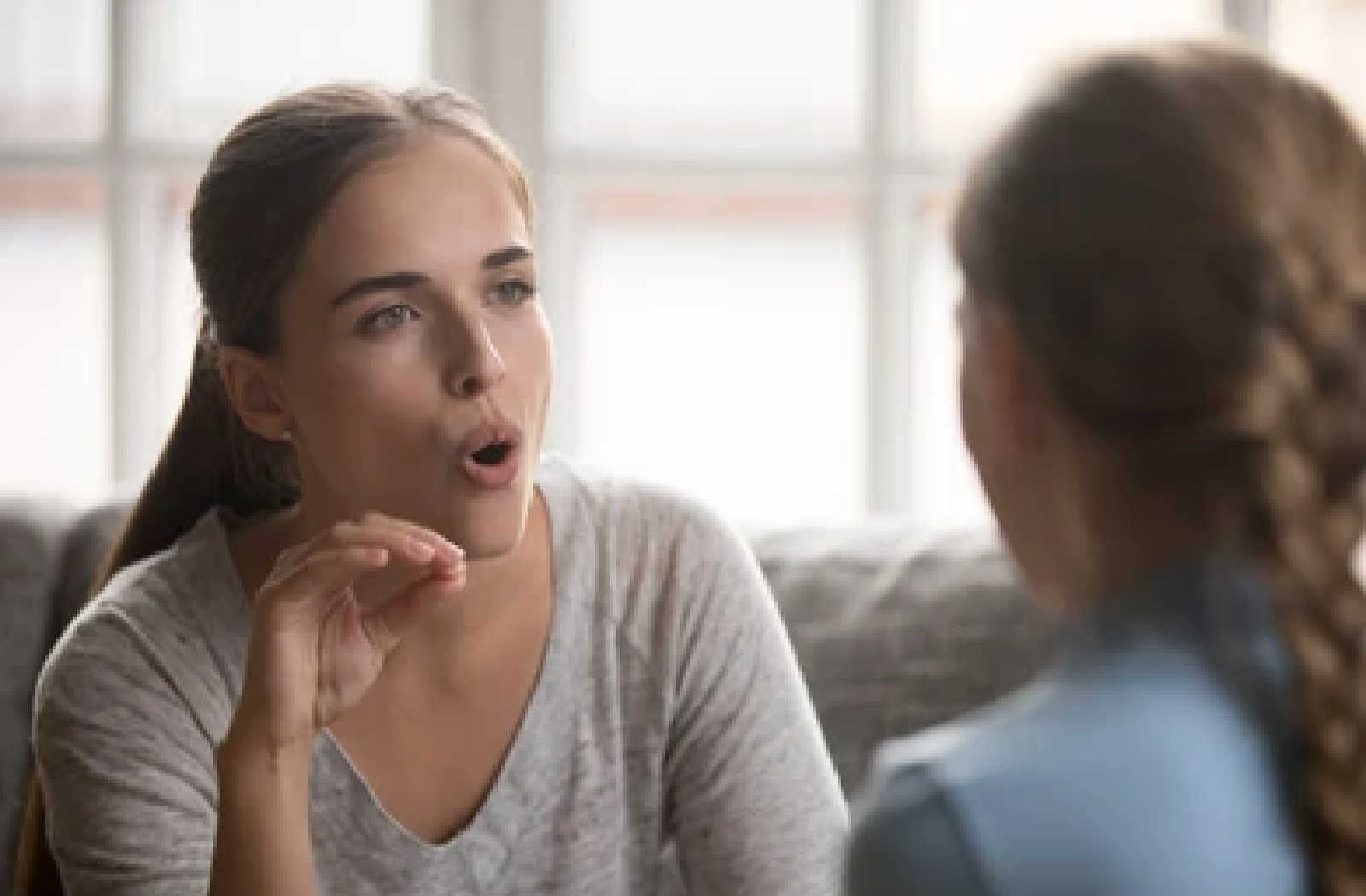 A woman practicing how to sound out different words with another woman