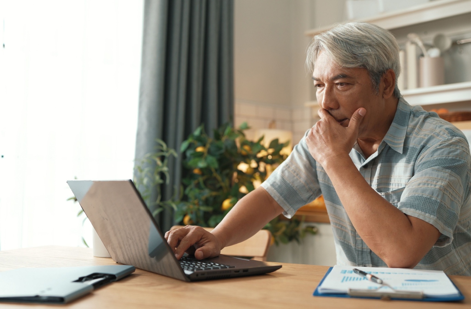 Older adult using a laptop appearing focused on online tasks highlighting safe internet practices for seniors.