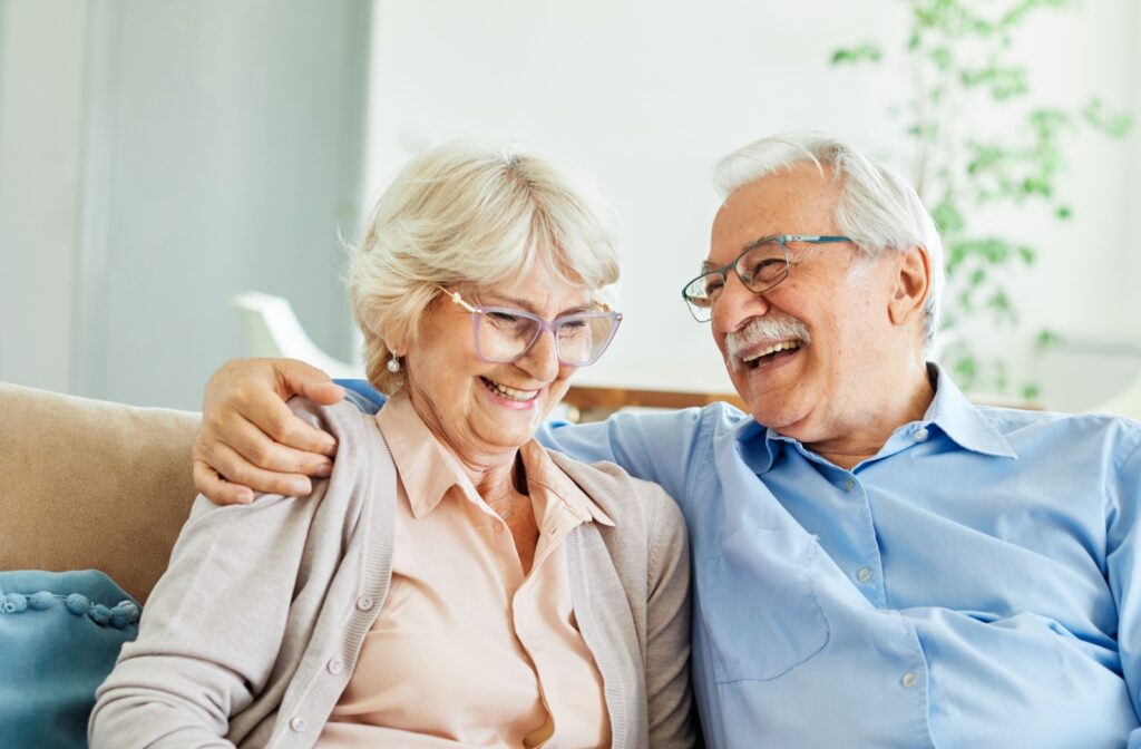 An oder couple laughing and hugging while in their home in senior living.
