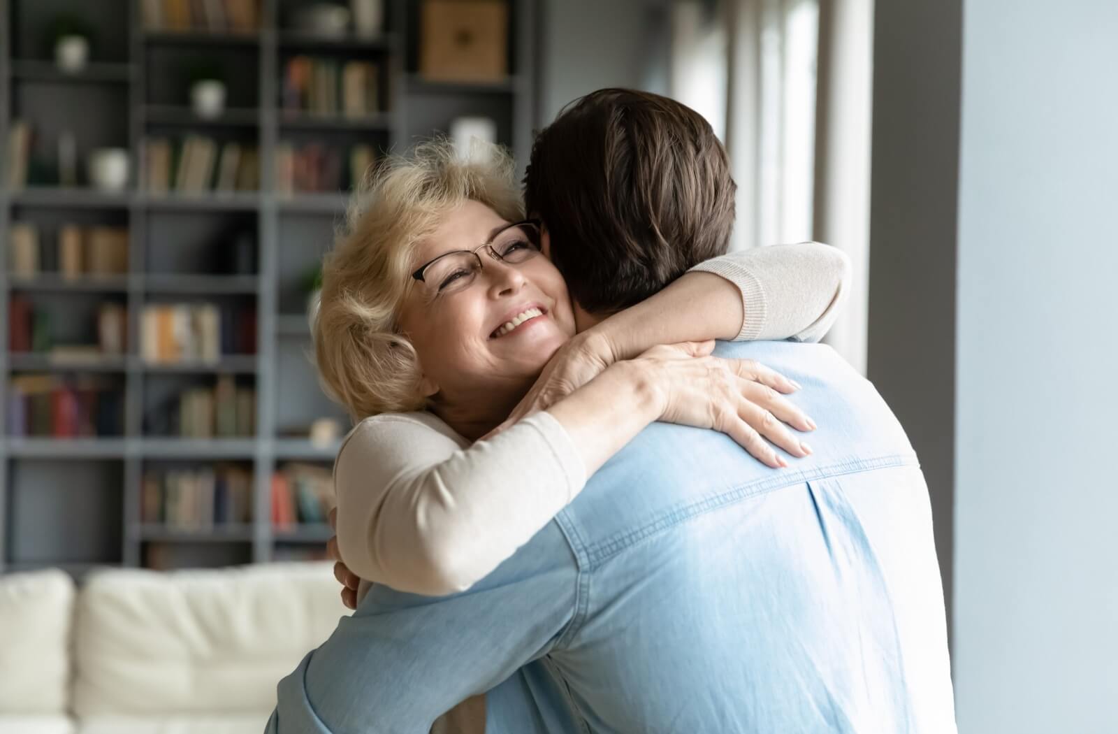 Someone hugs their parent, who lives in a memory care community.